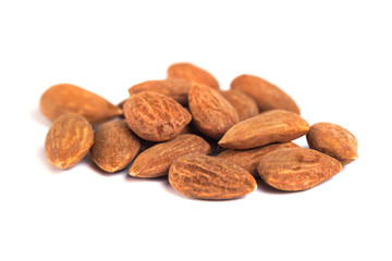 heap of brown roast almonds on white background