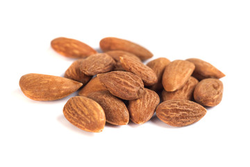 heap of brown roast almonds on white background