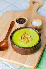 Spinach soup served on wooden board 