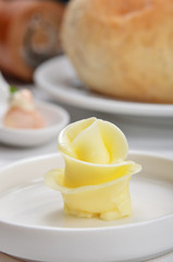 Flower shaped butter on white plate     