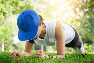 hand push-up. Confident muscled young women wearing sport wear and doing hand push-up while exercising on outdoor park