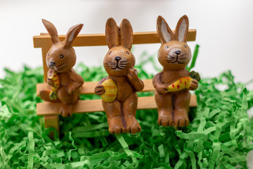decoration rabbits sitting on a bench near a window
