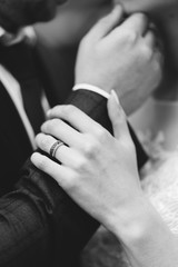 A man holds a woman by the chin, and she holds his hand, Hands of the bride and groom, Ring with...