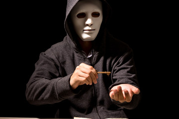 Hacker in a hood on dark background