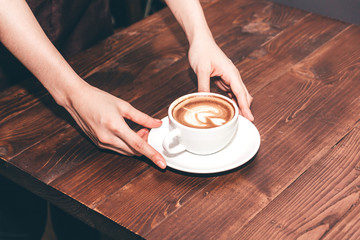 Barista holding coffee latte art in coffee shop