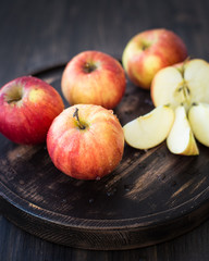 On a wooden stand fresh red apples. Wooden background