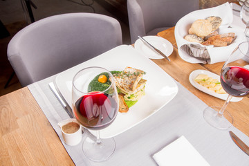 Fried zander, millet with green vegetables, fried boletus with thyme on a green leaf with some egg yolks served in a restaurant