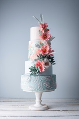 Wedding four-tiered cake decorated with spring red flowers and handmade pattern. Concept of...