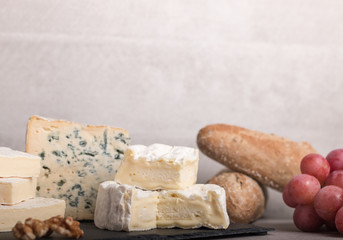  various french cheeses with red wina, grapes,baguette and nuts.