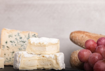  various french cheeses with red wina, grapes,baguette and nuts.