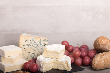  various french cheeses with red wina, grapes,baguette and nuts.