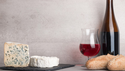  various french cheeses with red wina, grapes,baguette and nuts.