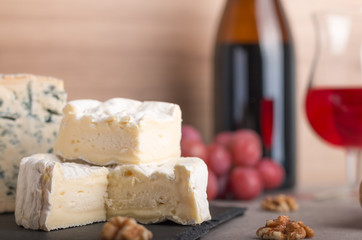  various french cheeses with red wina, grapes,baguette and nuts.