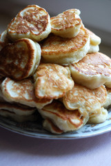 Thick russian pancakes piled on neutral background.