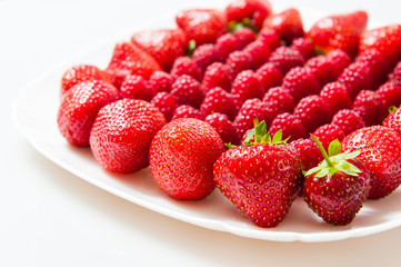 fresh raspberries and strawberries on a white plate