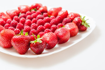 fresh raspberries and strawberries on a white plate