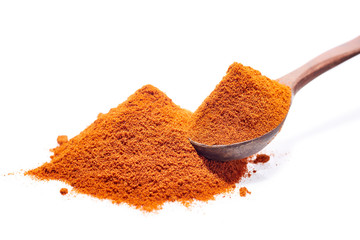 Wooden spoon full of paprica isolated on white background, close-up, top view, shallow depth of field