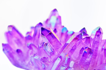 Amazing shiny Purple Quartz Aura crystals cluster with shallow depth of field closeup on white...