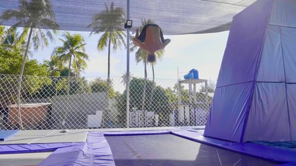 Professional gymnast jumping on the trampoline and doing tricks in air