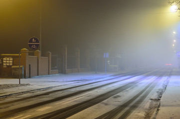 Ulica w zimową noc pokryta sniegiem i ślady samochodów. - obrazy, fototapety, plakaty