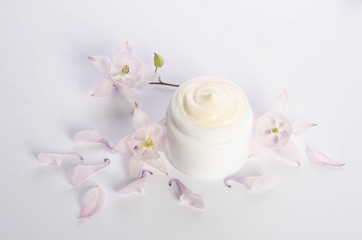 Fototapeta na wymiar Cute flowers and petal and a jar of natural body cream isolated on white background
