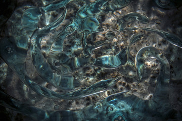 Floating oil swirl flowing slowly on the water surface 