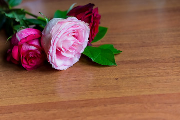 beautiful red roses flowers lie on a wooden table