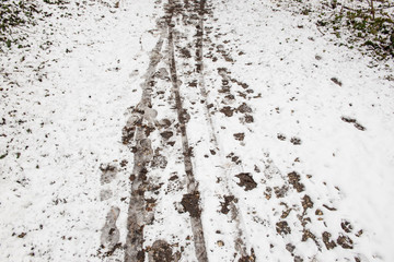 foot prints and tire tracks in the snow