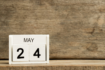 White block calendar present date 24 and month May on wood background