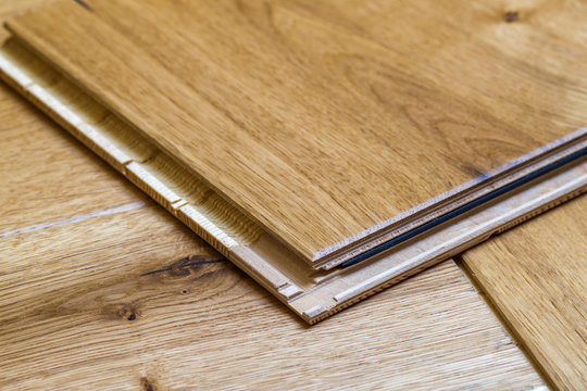 Brown wooden parquet floor planks installation , close up. Carpentry concept.