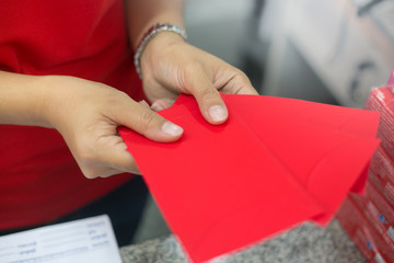 Hand holding red envelope to give in Chinese new year festival.