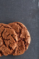 Chocolate chips cookies isolated on black background, macro, close-up, vertical