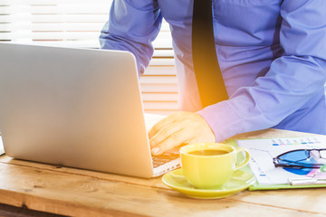 Business man analyzing investment charts with laptop computer and calculator on office desk table.Close up.Financial Report Revenue Statistical Accounting Concept.