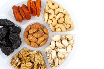 Mixture of fruits and nuts on a tray.  Isolated on white.