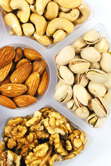 Fototapeta premium Mixture of fruits and nuts on a tray. Isolated on white.
