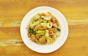 fried large rice noodles with pork and vegetable in black soy sauce on plate