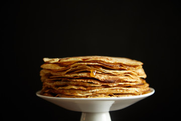 Crepes cake with orange jam and honey on white cake stand with text space. Pancake breakfast concept
