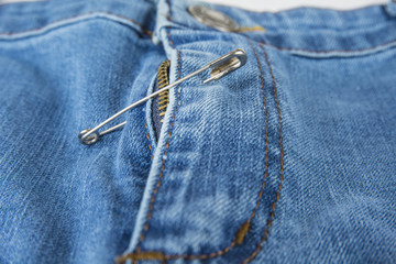 Broken blue jeans zipper fixed with safety pin © OttoPles