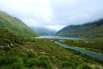 A lake on a misty day surrounded on three sides by mountains