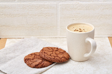 Cup of coffee and biscuit isolated on the white background, close-up, shallow depth of field.