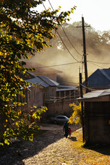 ancient small town at the foot of the mountains, paved street in the rays of the sun