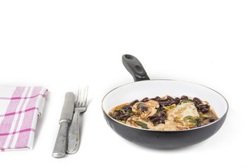 Chicken with beans and vintage fork and knife on the white