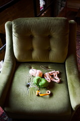 Crocheting tools on a green sofa chair