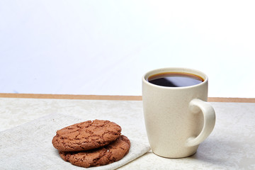 Cup of coffee and biscuit isolated on the white background, close-up, shallow depth of field.