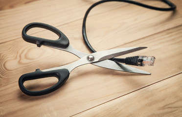 Scissors cutting internet cable.