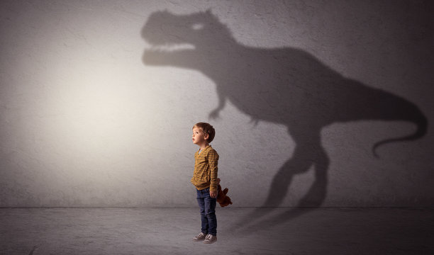 Dinosaurus shadow behind cute boy