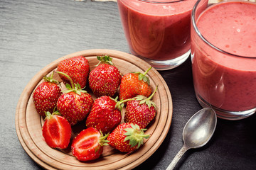 healthy strawberry yogurt with fresh berries on stone background