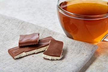 Top view close up picture of tea in glass cup with chocolate isolated on white background, vertical