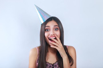 Close-up portrait of Beautiful woman wearing birthday cap . Woman surprise holds cheeks by hand