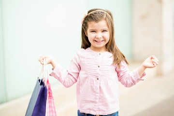 Cute young girl with shopping bags outside a mall